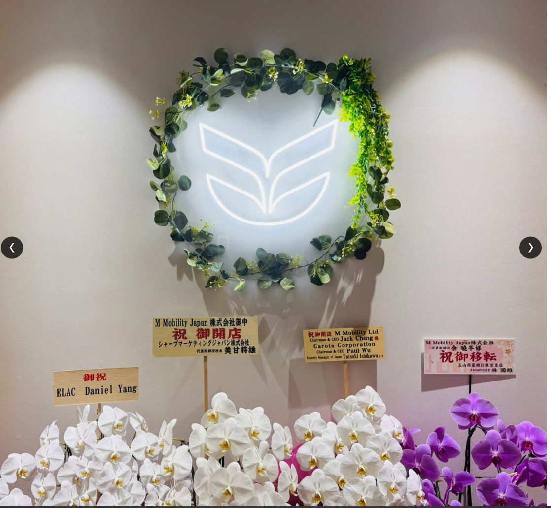 The M Mobility logo, lit in neon, at the new M Mobility office in Tokyo